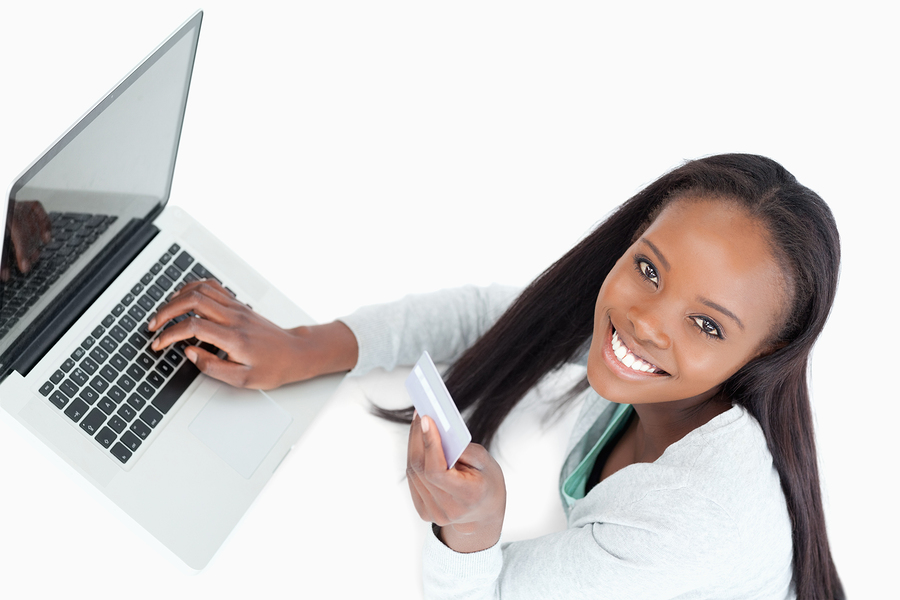 Smiling woman booking flight online against a white background